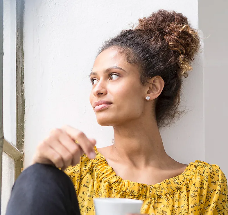 Woman looking out of a window at home